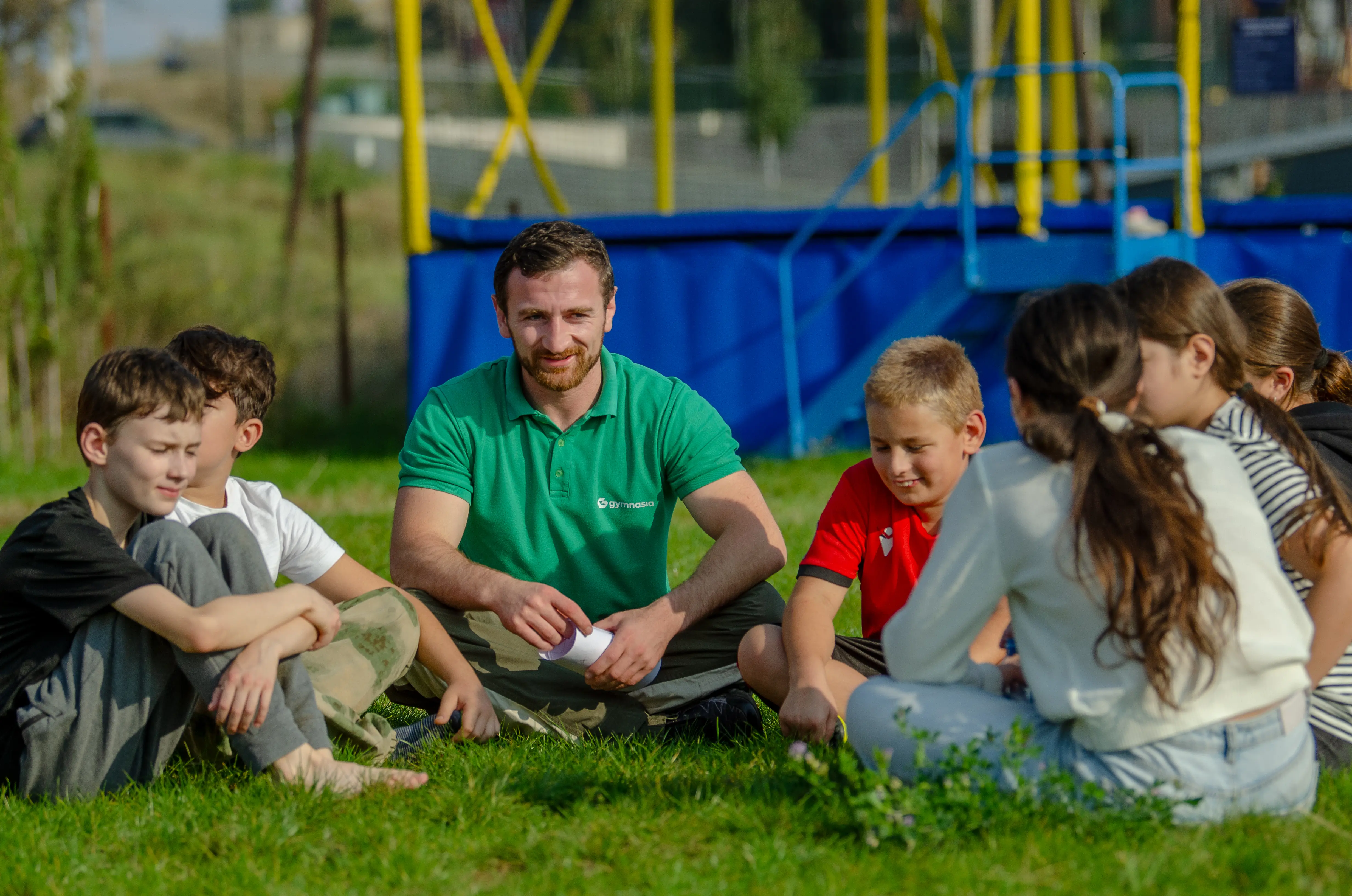 მწვრთნელი პატარებთან დაბრკოლებათა ბილიკზე Gymnasia-ში
